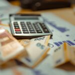 Euro banknotes and calculator on financial documents, focusing on business budget planning.