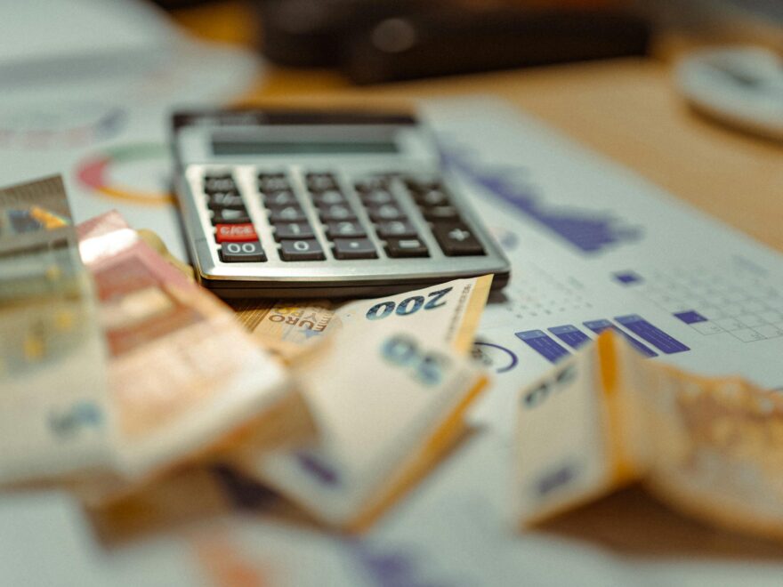 Euro banknotes and calculator on financial documents, focusing on business budget planning.