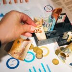 Euro bills and coins with financial charts showcasing budgeting and investment planning.