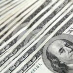 Detailed image showing a close-up of neatly stacked US dollar bills, ideal for financial and economic themes.