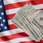 Top view of various dollar banknotes placed on flag of United States of America