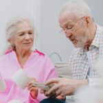Senior couple enjoying time together while looking at photographs, smiling and reminiscing.